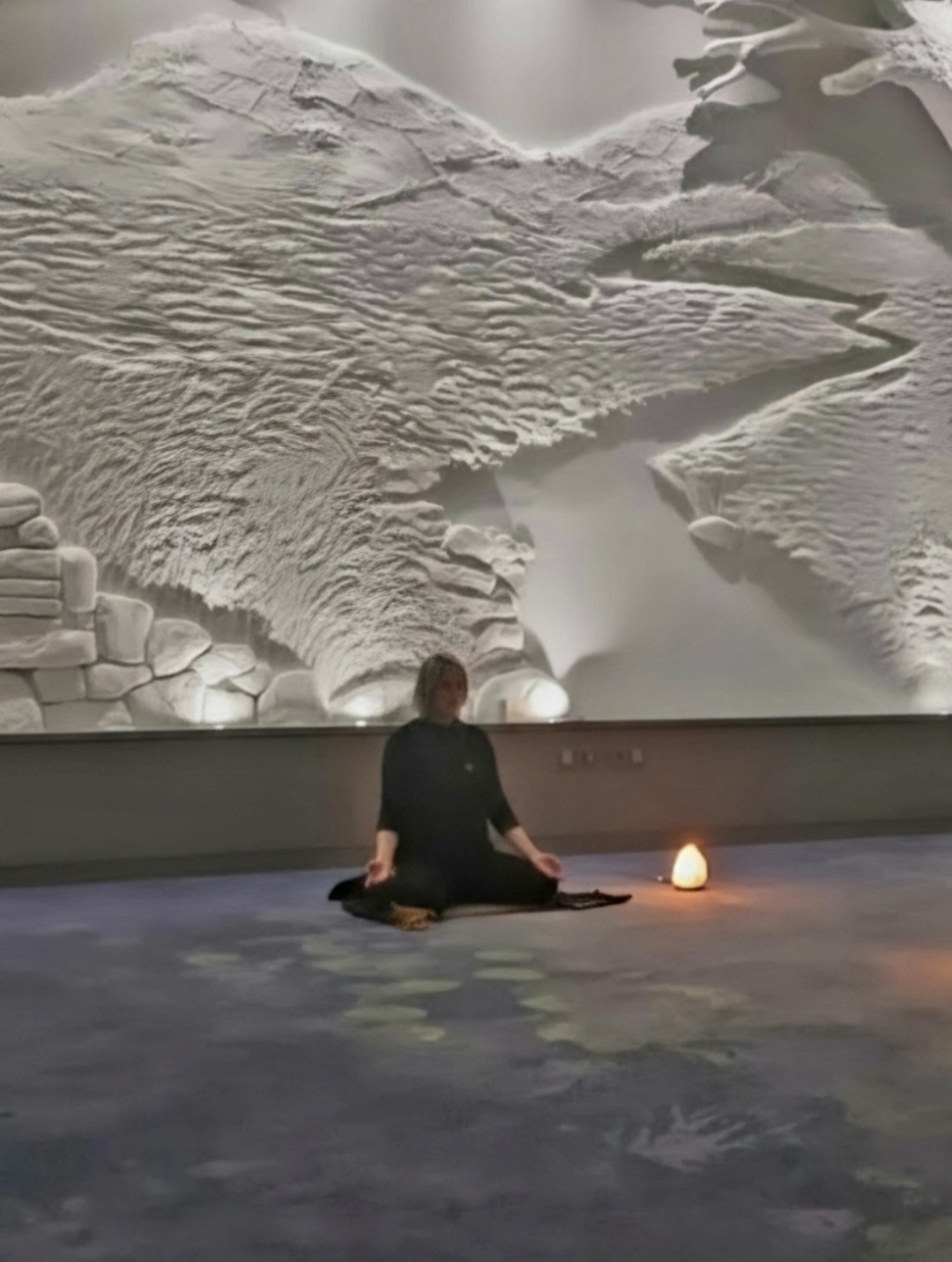 Alma seated in meditation in a calm, softly lit space